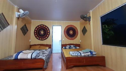 two twin beds in a room with two mirrors at Bungalow Du Gia in Làng Cac