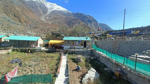 a group of buildings with a mountain in the background at Hotel Inn Badrinath Stay in Badrīnāth