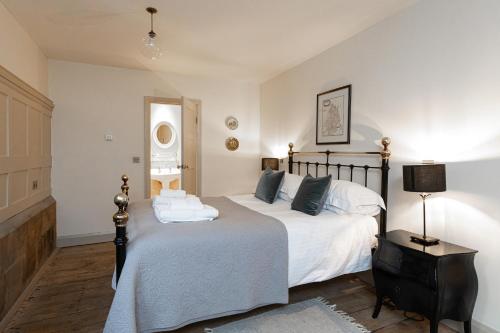 a bedroom with two beds with white sheets and a lamp at Greystead Old Church in Hexham
