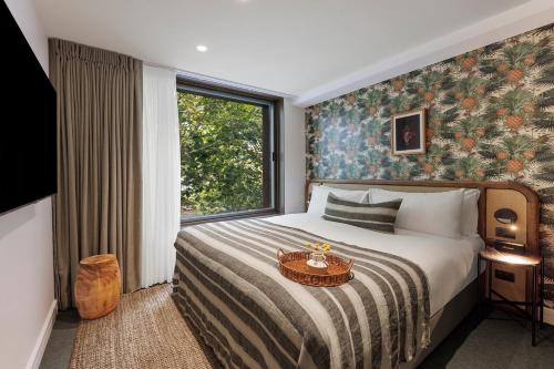 a bedroom with a bed and a large window at 202 Elizabeth Hotel - The Surry - Australia in Sydney