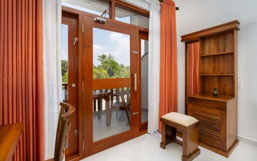 um quarto com uma porta, uma secretária e uma janela em Peekwood em Matara