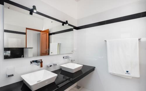 uma casa de banho com 2 lavatórios e um espelho em Peekwood em Matara