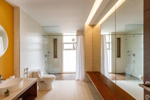 a bathroom with a toilet and a sink and a shower at JalMahal by JadeCaps Bay View & Pool Dabolim in Vasco Da Gama