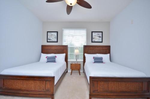 a bedroom with two beds and a ceiling fan at Beautiful Modern Condo, Near Parks-2012 in Orlando