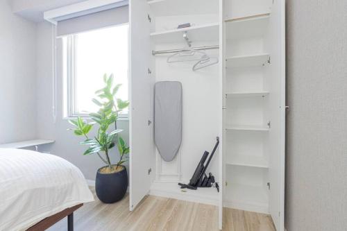 a bedroom with a white closet with a mirror at ホステルアミーチ Hostel Amici in Tokyo