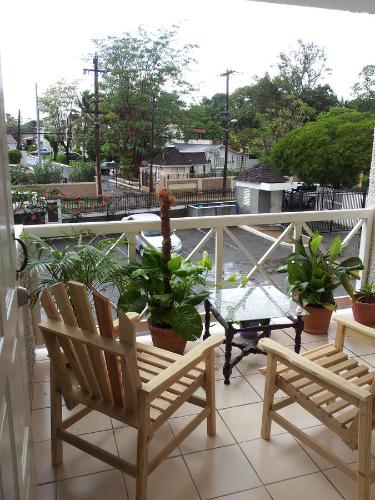 a balcony with two chairs and a table and potted plants at Cozy Waterloo Apartment in Kingston