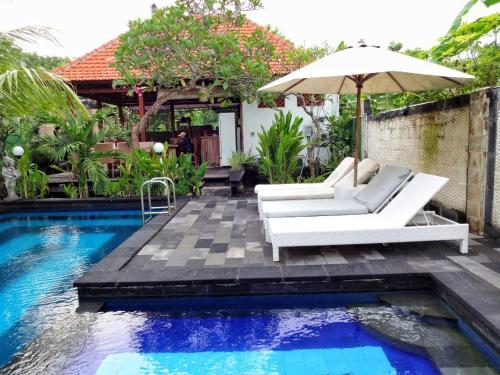 une terrasse avec un parasol, des chaises et une piscine dans l'établissement Villa Cempaka Lembongan, à Nusa Lembongan