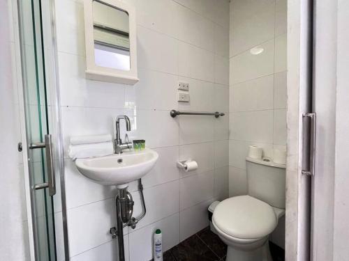 a white bathroom with a toilet and a sink at Budget 1 bedroom unit near Maroubra Beach in Sydney