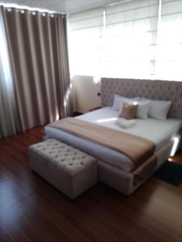 a bedroom with a large bed and a ottoman at cyber city hotel kandy in Kandy