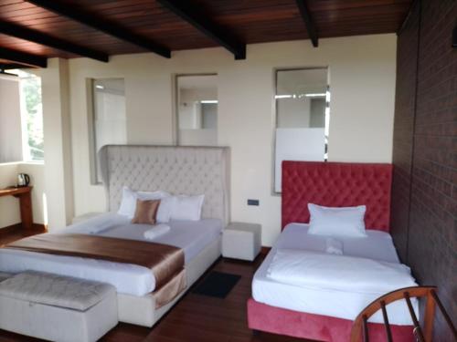 a bedroom with two beds and a couch at cyber city hotel kandy in Kandy