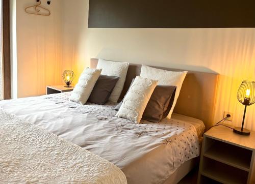 a bedroom with a white bed with pillows at B&B au 27 in Stavelot