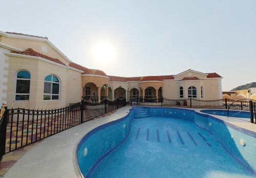 uma casa com uma piscina em frente em Mountains resort by escape time em Fujairah