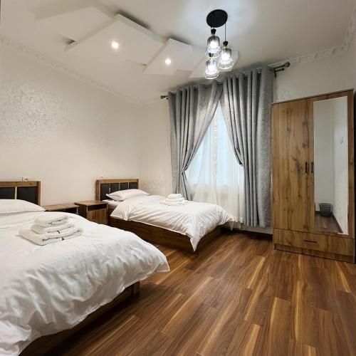 1 dormitorio con 2 camas y ventana en Cozy Hostel, en Yunusobod