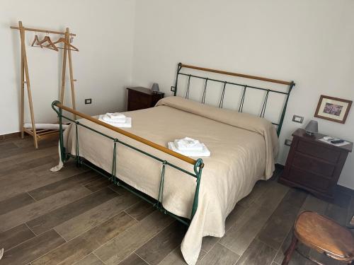 a bedroom with a bed and a wooden floor at Borgo dei Centenari in Orgosolo