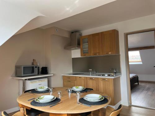 une cuisine avec une table en bois et des plaques de cuisson. dans l'établissement Appartement rive droite, à Boulogne-sur-Mer