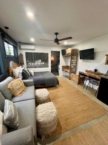 a living room with a bed and a couch at Sunnyside Studio - Pet Friendly Luxury Escape in Port Macquarie