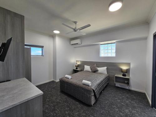 a bedroom with a bed and a ceiling fan at Y Motels Rockhampton in Rockhampton