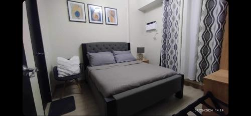 a small bedroom with a bed and a chair at 1BR with extra room at One Regis- Megaworld in Bacolod
