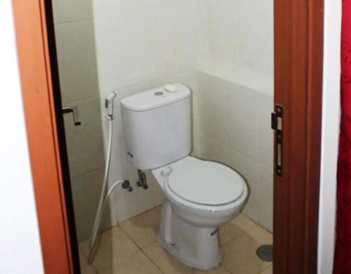 a bathroom with a white toilet in a room at Pelangi Rooms By Reccoma in Pondokcabe Hilir