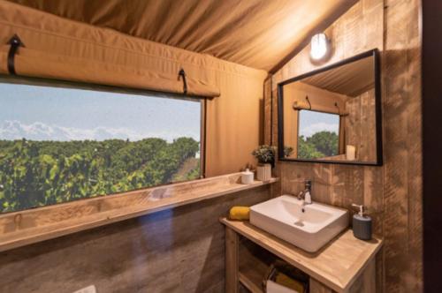 La salle de bains est pourvue d'un lavabo et d'une grande fenêtre. dans l'établissement Ushuaïa Villages La Buissonnière Lodges, à Chisseaux