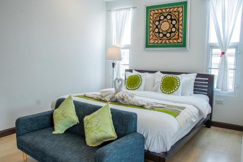 a bedroom with a large bed and a couch at Aba Village حلال in Chiang Mai