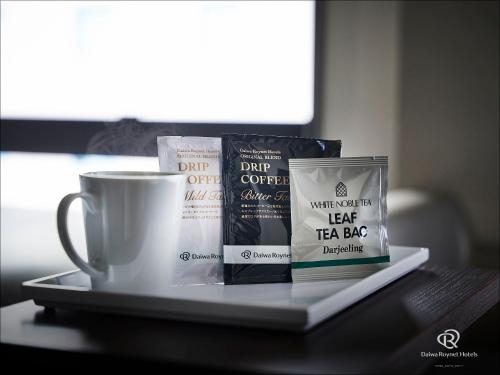 a tray with a cup of coffee and tea bags at Daiwa Roynet Hotel Naha Omoromachi in Naha