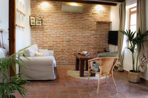 un soggiorno con un divano e un muro di mattoni di Apartamento Cebada a Valladolid