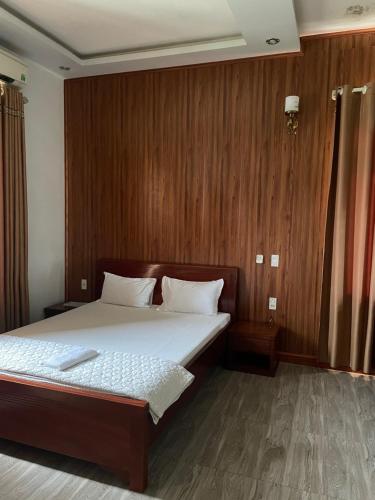 a bedroom with a large bed with wooden walls at Trúc Lâm hotel in Hải Dương