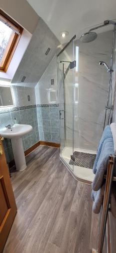 uma casa de banho com um chuveiro e um lavatório. em Caisteal Liath House em Lochinver