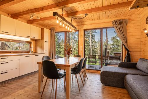 een keuken en een woonkamer met een tafel en stoelen bij Forest Princess Chalet - Happy Rentals in Nova Vas