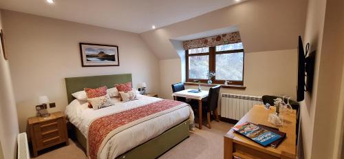 a bedroom with a bed and a desk and a window at Caisteal Liath House in Lochinver