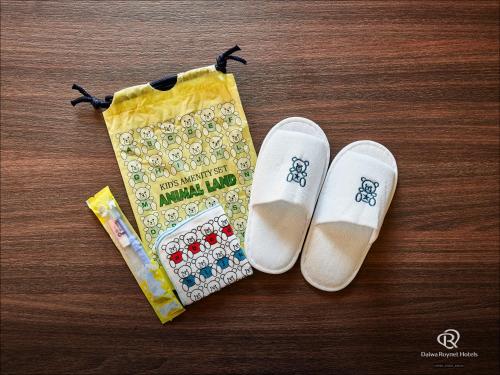 a pair of white shoes and a bag on a table at Daiwa Roynet Hotel Naha Omoromachi in Naha