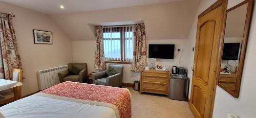 a hotel room with a bedroom with a bed and a television at Caisteal Liath House in Lochinver