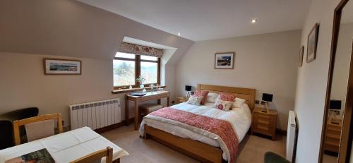 a bedroom with a bed and a desk and a window at Caisteal Liath House in Lochinver