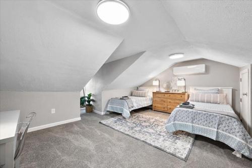 a attic bedroom with two beds and a dresser at Cozy Southside Pitt home w/ Pool Table +Yard in Pittsburgh