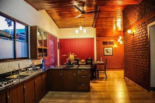 cocina con mesa y pared roja en The Tenthola en Kandy