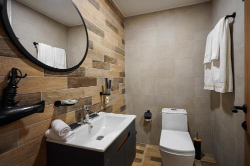 a bathroom with a sink and a mirror and a toilet at Felinger Concept Hotel in Yerevan