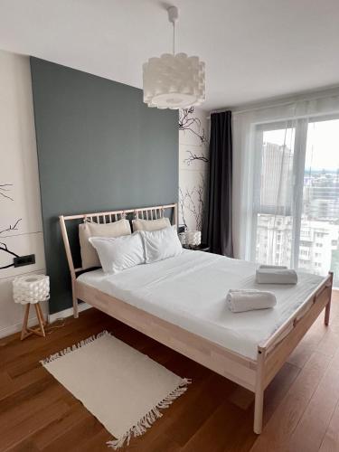 ein Bett in einem Zimmer mit einem großen Fenster in der Unterkunft Homeland City View in Cluj-Napoca