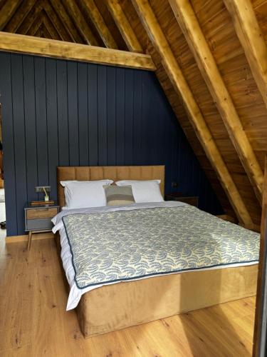 a bedroom with a large bed in a attic at Natura Magura in Buzău