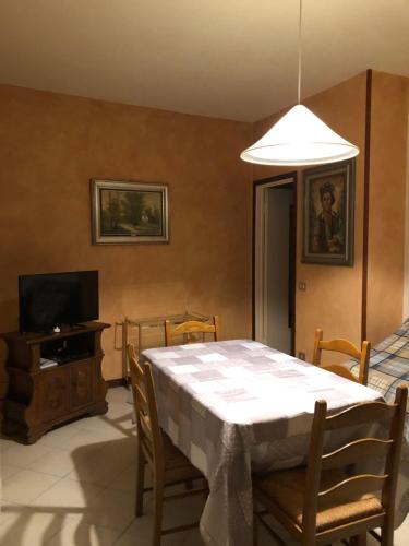 uma sala de jantar com uma mesa e uma televisão em Il Castello em CastellʼArquato