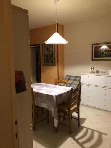 uma sala de jantar com mesa e cadeiras e uma luz em Il Castello em CastellʼArquato