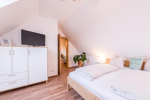 a bedroom with a bed and a tv on a white cabinet at Weingut Dietl in Riegersburg