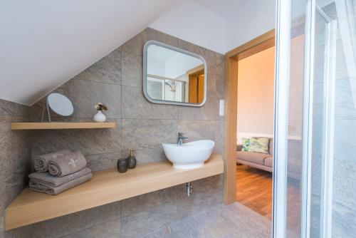 La salle de bains est pourvue d'un lavabo et d'un miroir. dans l'établissement Weingut Dietl, à Riegersburg