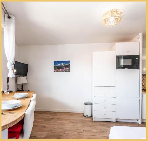 Il comprend une cuisine équipée d'un bureau et d'un réfrigérateur blanc. dans l'établissement Appartement Central I Annemasse, à Annemasse