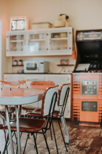 a kitchen with a table and chairs and an oven at The ReTrO Beach Shack in Aldinga Beach
