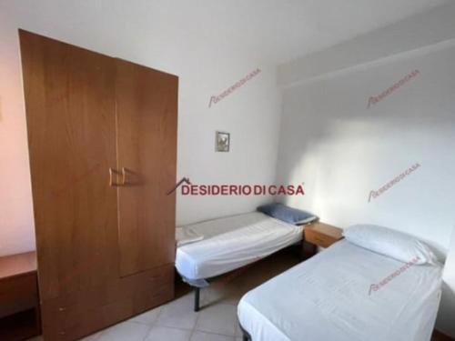 Habitación con 2 camas y puerta de madera en Villa sedna, en Campofelice di Roccella