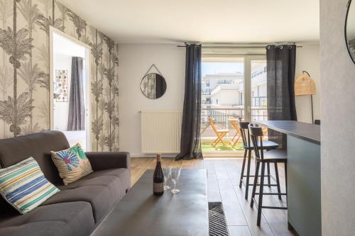 a living room with a couch and a table at L'élégant - Desaugiers in Lyon