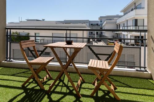 une table en bois et deux chaises sur un balcon dans l'établissement L'élégant - Desaugiers, à Lyon