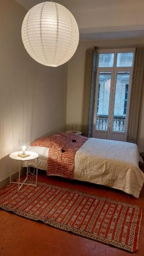 - une chambre avec un lit, une table et deux lumières dans l'établissement Appartement Allées Paul Riquet, à Béziers
