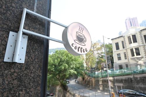 a sign for a coffee shop on the side of a building at Mini Central in Hong Kong
